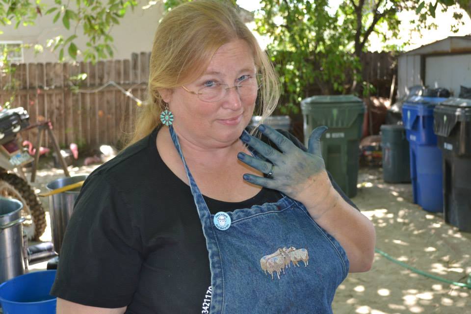 a photo of Ercil Howard Wroth, a white woman with dark blonde hair. One of her hands is dyed blue from indigo.